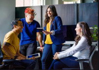 four people around a desk