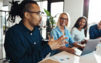 four people sitting around a desk