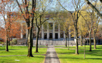 picture of college campus with a building and students off in the distance