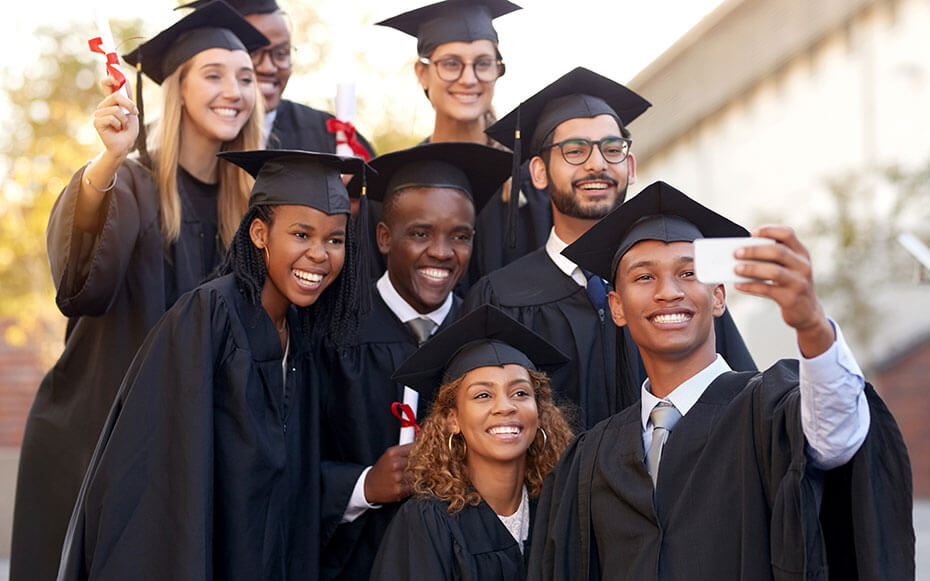 A group of college graduates taking a selfie.