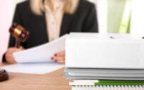 Woman with a gavel reviewing papers