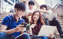 students sitting on stairs working in groups