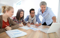 group of people working together at a desk