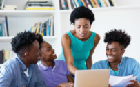 Four students looking at computer