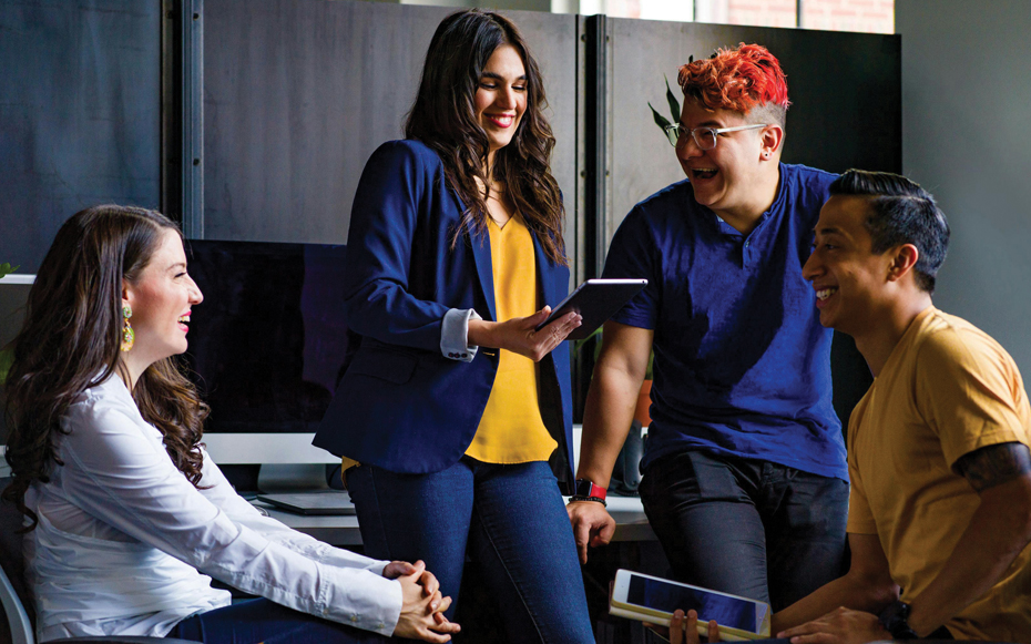 A group of workers laughing in the office.