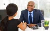 A man engages a new employee to ensure she is onboarded correctly.