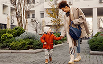 A mother takes a walk with her child in between attending online classes.