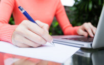 employer sitting at a desk writing on a piece of paper