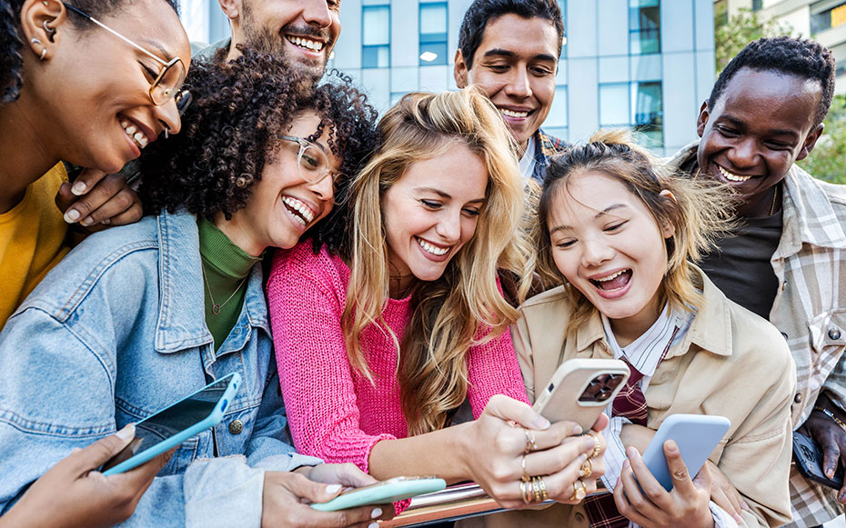 A group of college kids looking at their cell phones.