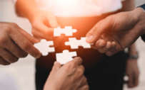 Four people standing with puzzle