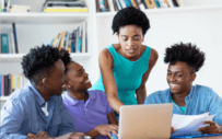 four people looking at laptop screen